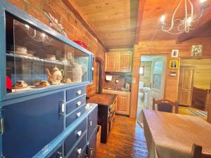 a kitchen with a blue cabinet and a table in a room at Hotel Oka i Po in Berane