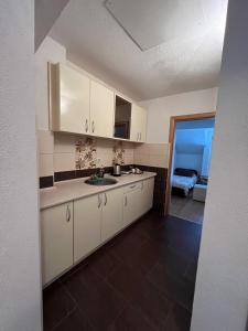 a kitchen with white cabinets and a sink at A&M Apartments in Ohrid