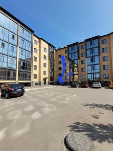 a parking lot with a blue slide in front of buildings at Апартаменты Luxe в центре города in Kokshetau