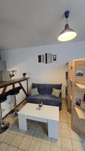 a living room with a couch and a table at Perle des Bords de Loire in Blois +1 photo