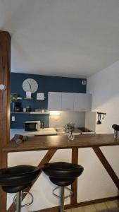 a kitchen with a counter and two stools in it at Perle des Bords de Loire in Blois