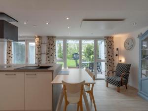 Holiday Home Sint Maartenszee Garden Bliss في Sint Maartensvlotbrug: مطبخ مع طاولة وكراسي وغرفة طعام