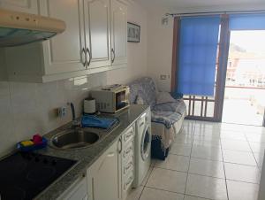 a small kitchen with a sink and a microwave at One bedroom Apartment Los Diamantes Annemarie Los Cristianos in Los Cristianos