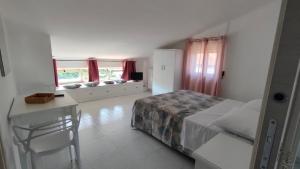 una camera da letto con un letto, un tavolo e una scrivania di Casa Tortorella a Vallo della Lucania