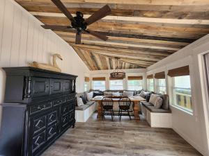 a living room with a wooden ceiling and a table at Lake Greenwood Lodge Main House and guesthouse in Isle of Pines +26 photos