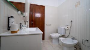 a white bathroom with a toilet and a sink at Casa Conceição in Ribeira Brava +78 photos