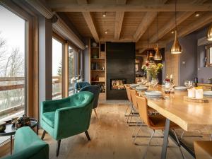 Un comedor con una mesa larga y sillas. en Chalet Caprice - OVO Network, en Combloux