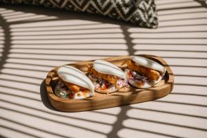 three oysters on a wooden plate on a table at Ammos Boutique Apartments & Suites in Malia