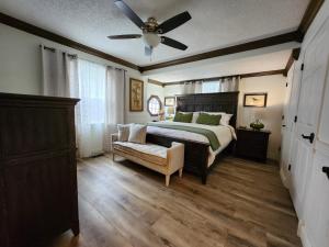 a bedroom with a bed and a ceiling fan at Lake Greenwood Lodge Main House and guesthouse in Isle of Pines