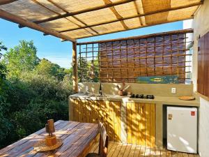 an outdoor kitchen with a wooden table and a wooden table at Vila Alto do Rio Caraíva in Porto Seguro