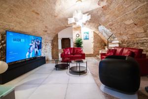 モルフェッタにあるDimora San Roccoの赤い家具と大きなテレビのあるリビングルーム