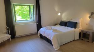 una camera da letto con un grande letto bianco con una finestra di La Treille - Grand jardin avec Piscine & Tennis a Saint-Hilaire-du-Bois Altre 17 foto