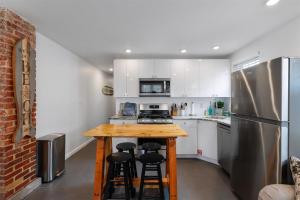 Una cocina con una encimera con taburetes y un refrigerador. en 309 E Hildreth Ave, Unit 1, en Wildwood
