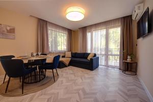 a living room with a blue couch and a table at Messambria Beach Apartments in Sveti Vlas