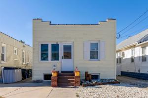 una casa blanca con una puerta principal y escaleras en 108 W 20Th Ave, Unit 1, en North Wildwood