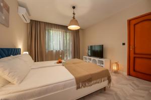 a bedroom with a large bed and a television at Messambria Beach Apartments in Sveti Vlas +38 photos