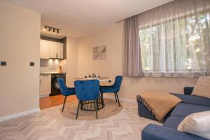 a living room with a blue couch and a table at Messambria Beach Apartments in Sveti Vlas