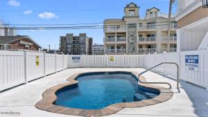 una piscina con una valla blanca y un edificio en Residence 101S At The Sandcastle Condominiums, en Wildwood Crest