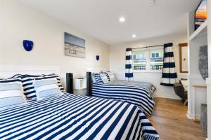 威尔伍德克拉斯特415 E Atlanta Ave, Unit 107的一间卧室配有两张带条纹床单的床