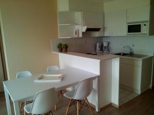 a kitchen with a table and chairs and a white counter top at Apartment Green Garden Block L in Middelkerke