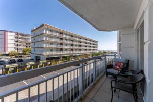 a balcony with two chairs and a building at Residence 101 At The Grand in Wildwood