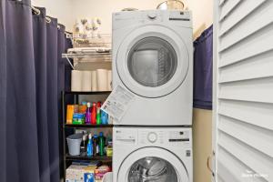 a washing machine and a washer in a laundry room at 401 E Stanton Rd, Unit 203 in Wildwood Crest