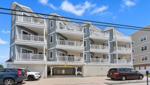 a large apartment building with cars parked in front of it at 401 E Stanton Rd, Unit 203 in Wildwood Crest