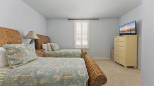 a bedroom with a bed and a dresser and a television at Residence 306 At The Grand in Wildwood +23 photos