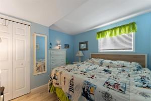 a bedroom with a bed with blue walls and a window at 7203 Atlantic Ave, Unit 101 in Wildwood Crest +23 photos