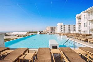 a large swimming pool with chairs and a building at Residence 509 At The Grand in Wildwood