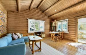 a living room with a blue couch and a table at Atmospheric Log Cabin By Myllavannet 