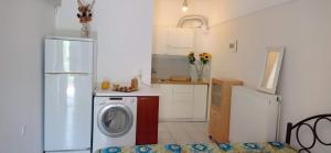 a kitchen with a refrigerator and a washing machine at Small and practical Νο1 in Límni