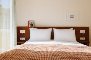 a bedroom with a bed with white pillows at ALFRED HOTELS Les Halles in Biarritz