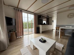 a living room with a table and a large window at 89, Groenvink - one with nature! in Oisterwijk