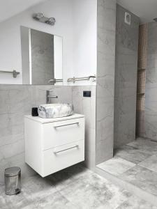 a white bathroom with a sink and a mirror at Ranczo Nowodworce - pokoje do wynajęcia in Nowodworce