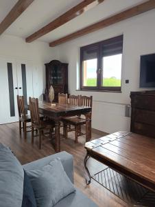 a living room with a wooden table and chairs at Ranczo Nowodworce - pokoje do wynajęcia in Nowodworce +2 photos