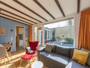 a living room with a couch and a table at Bungalow in Sint Maartenszee near Dunes in Sint Maartensvlotbrug