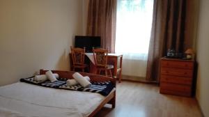 Schlafzimmer mit einem Bett, einem Tisch und einem Fenster in der Unterkunft Restauracja - Hotel Nova in Skępe