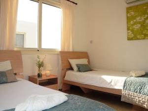 Un dormitorio con dos camas y una ventana. en Vanessa 2 bedroom apartment, en Pafos 8 fotos más