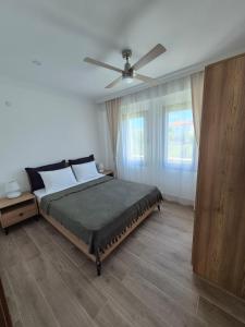 a bedroom with a bed with a ceiling fan at Datcha Cozyhomes Reşadiye in Datca