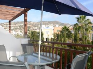 una mesa y sillas en un balcón con sombrilla en Vanessa 2 bedroom apartment, en Pafos