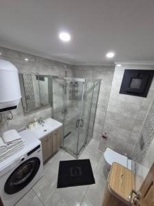 a bathroom with a shower and a washing machine at Datcha Cozyhomes Reşadiye in Datca