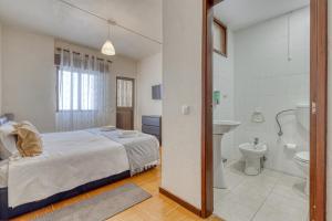 Un dormitorio con una cama, un lavabo y un inodoro. en Hotel Borsalino, en Oporto