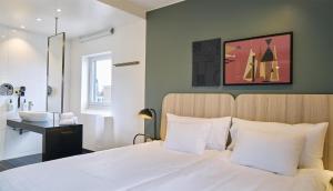 a bedroom with a white bed and a sink at Scandic Malmen in Stockholm