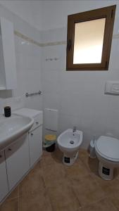 ラ・マッダレーナにあるSummer home96の洗面台とトイレを備えた白いバスルーム