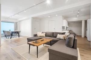 a living room with a couch and a table at Amazing view I Fjellheisen I FREE Parking in Tromsø