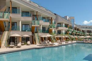 a hotel with a swimming pool with chairs and umbrellas at Liberty Signa in Fethiye