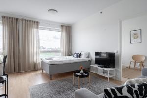 a white room with a bed and a tv at "Pyynikinkulma" - 1BR Apt with Stunning Views, Sauna & Balcony in Tampere