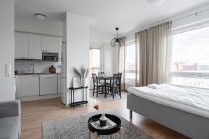 a bedroom with a bed and a kitchen with a table at "Pyynikinkulma" - 1BR Apt with Stunning Views, Sauna & Balcony in Tampere