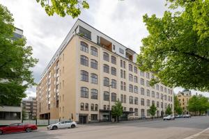 an apartment building on a street with cars parked in front at "Pyynikinkulma" - 1BR Apt with Stunning Views, Sauna & Balcony in Tampere